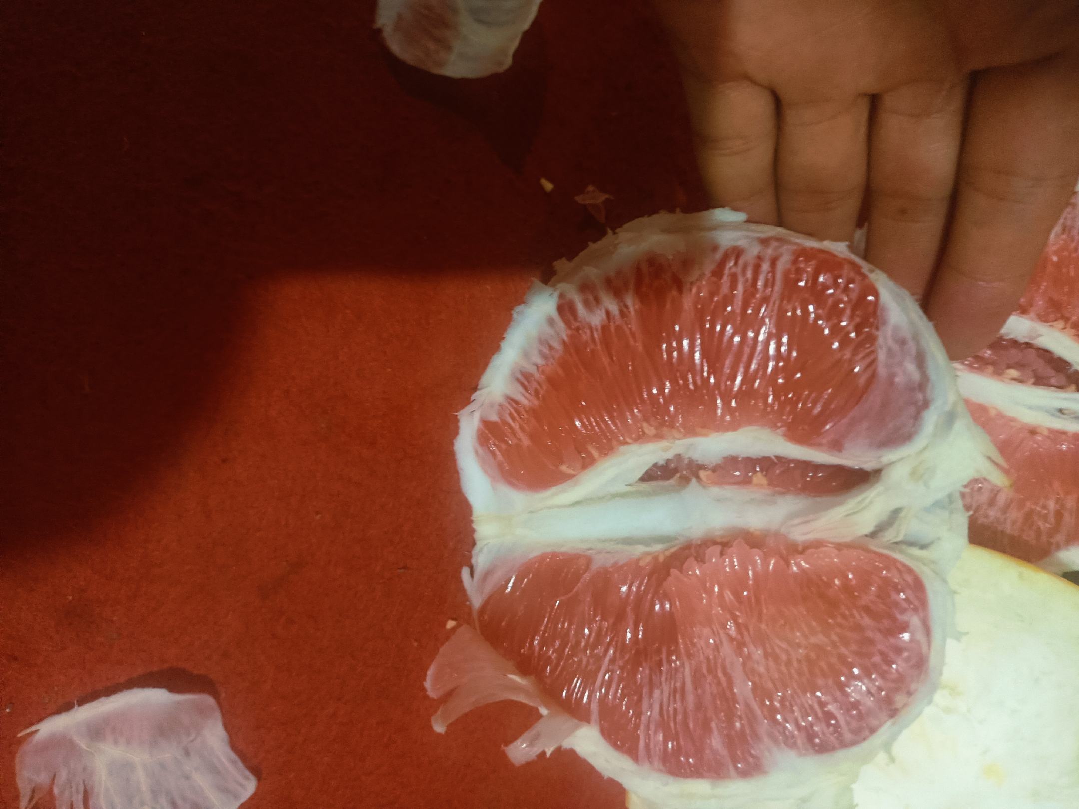 厨师正在用刨刀刨取甜橙外皮,橙皮细丝清晰可见,旁边是剥好的橙肉果粒 处理甜橙