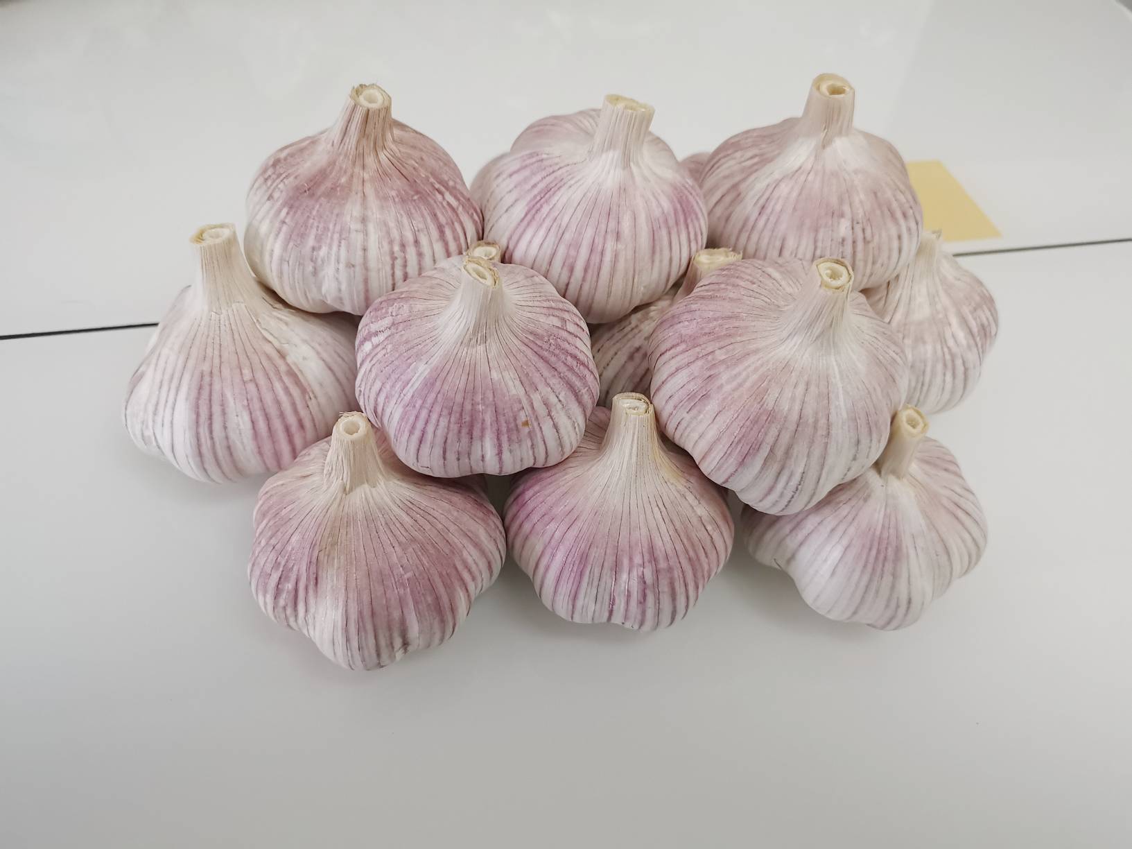 一罐晶莹剔透的紫皮泡蒜成品摆放在木质桌面上,色泽诱人 紫皮泡蒜成品展示