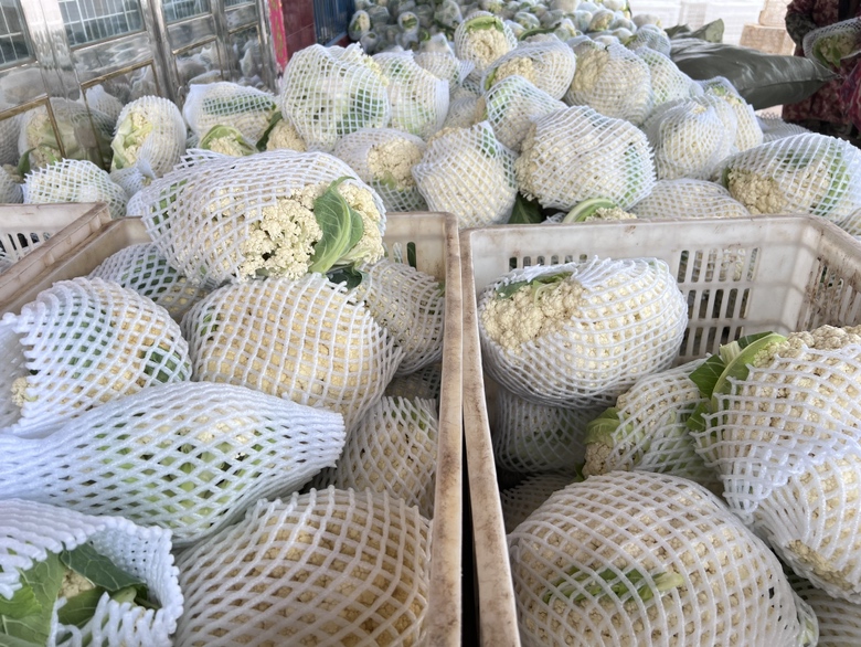 市场摊位上摆放整齐的新鲜松花菜