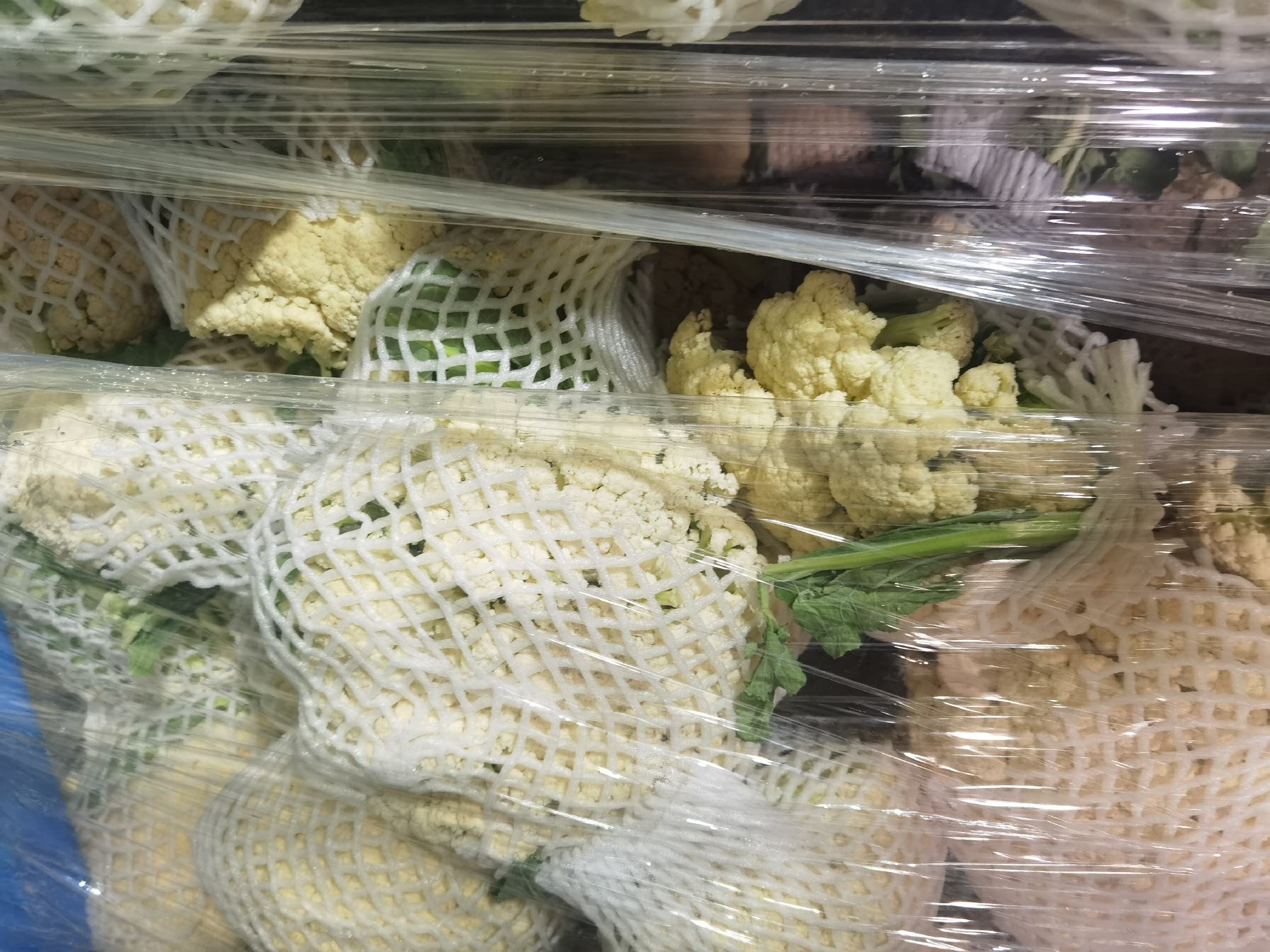 一杯透明玻璃杯中漂浮着几片菜花叶,旁边摆放着新鲜的白花菜花 菜花叶泡水饮用示意图