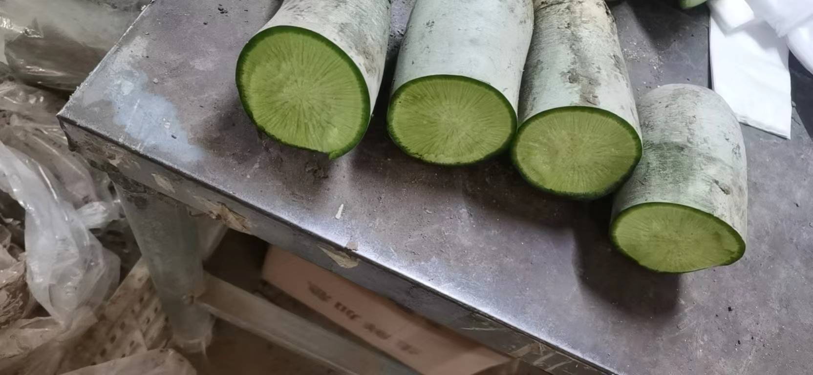 青萝卜切开后的横截面,呈现出晶莹剔透的质地,颜色翠绿,纹理清晰 青萝卜切片特写图