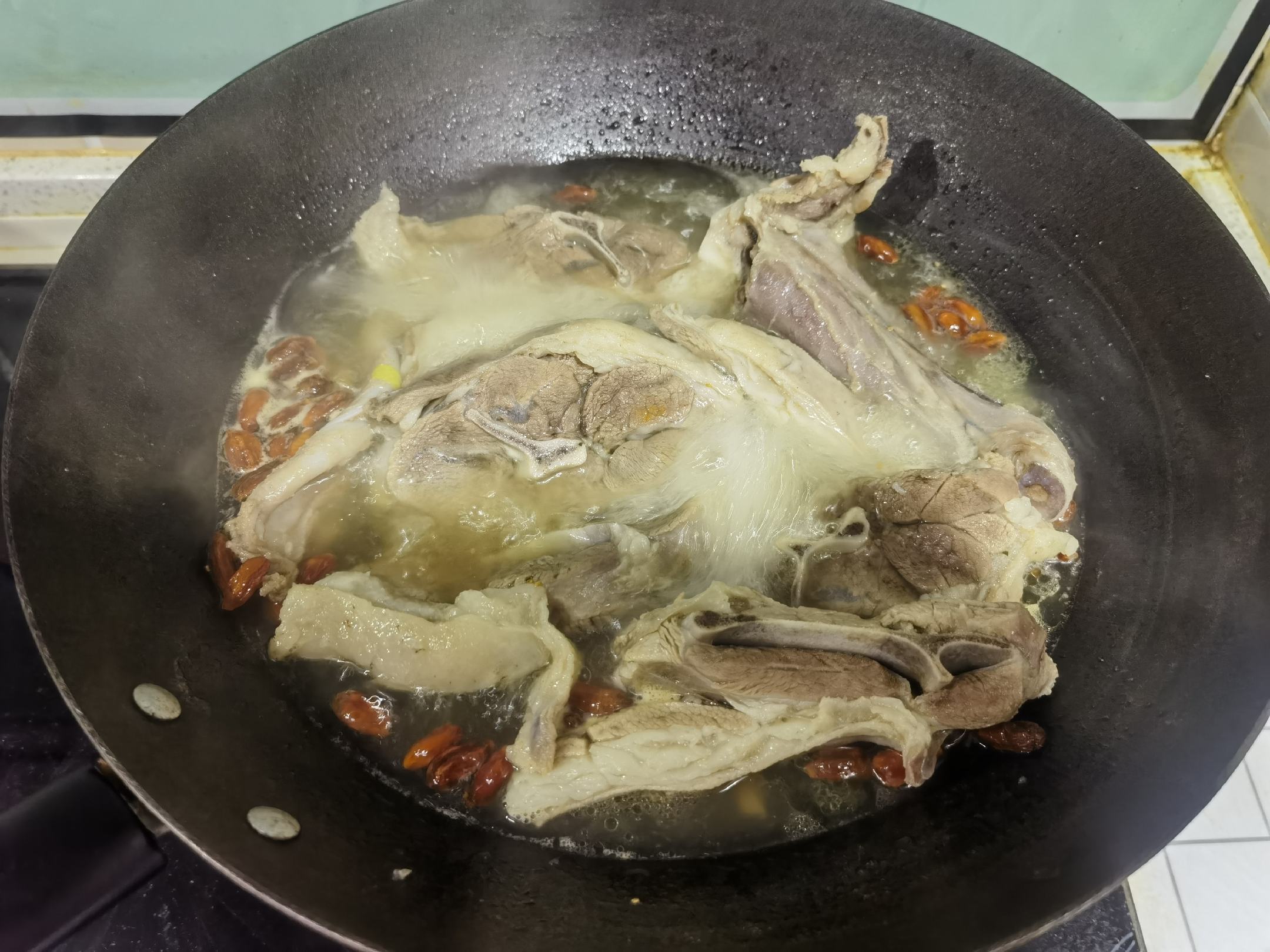 羊肉汤正在慢炖过程中,锅中蒸汽缭绕,香气四溢 慢炖过程图