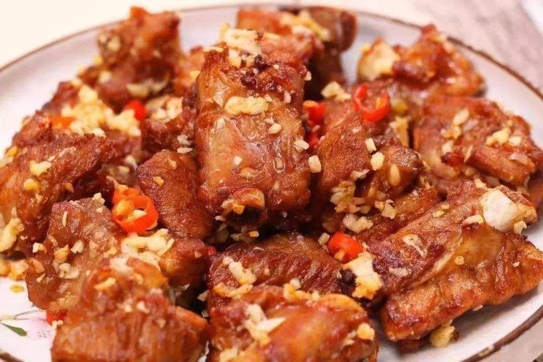 锅中排骨与蒜薹正在炖煮,汤汁浓稠,香气四溢 蒜薹与排骨炖煮状态