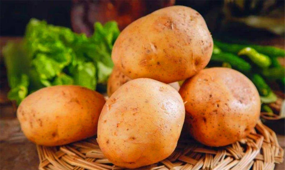 新鲜番茄和土豆摆放在案板上,旁边有刀具和砧板 新鲜番茄和土豆摆放在案板上