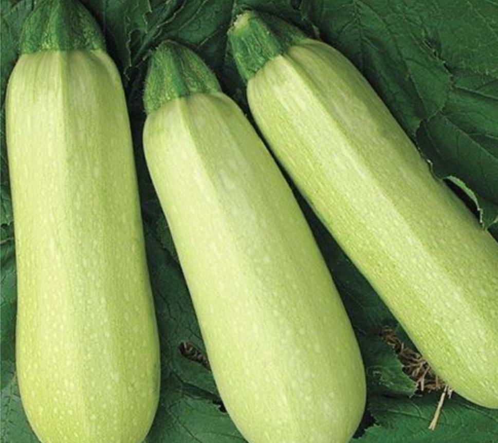 胡萝卜菠菜香蕉汁成品图,绿色与橙色渐变的果汁,旁边摆放胡萝卜、香蕉和菠菜叶装饰 胡萝卜菠菜香蕉汁成品图