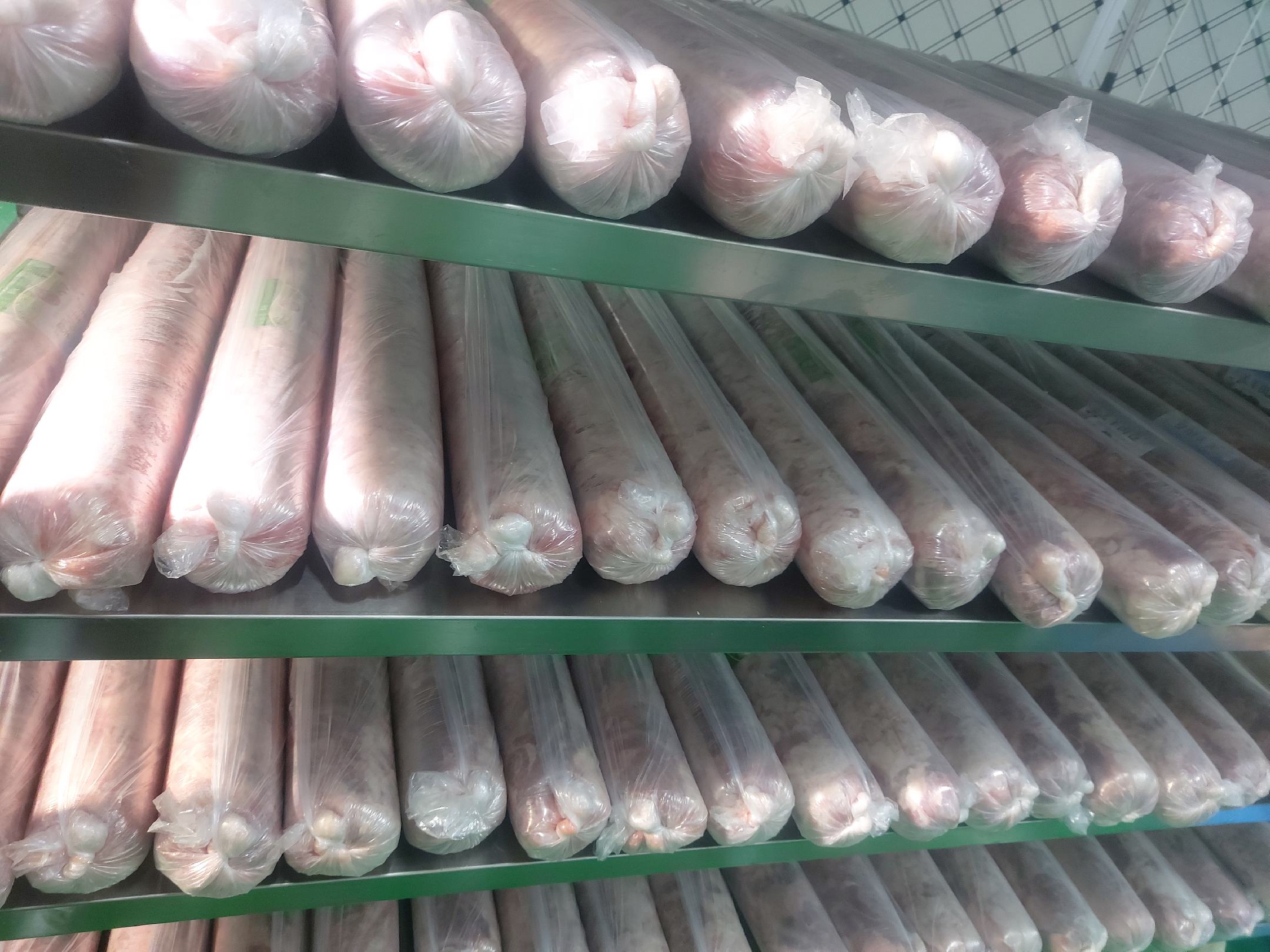 展示多种白条羊肉产品,如羊肉卷、羊肉串、真空包装羊肉块等,陈列在货架或冷柜中 白条羊肉产品展示