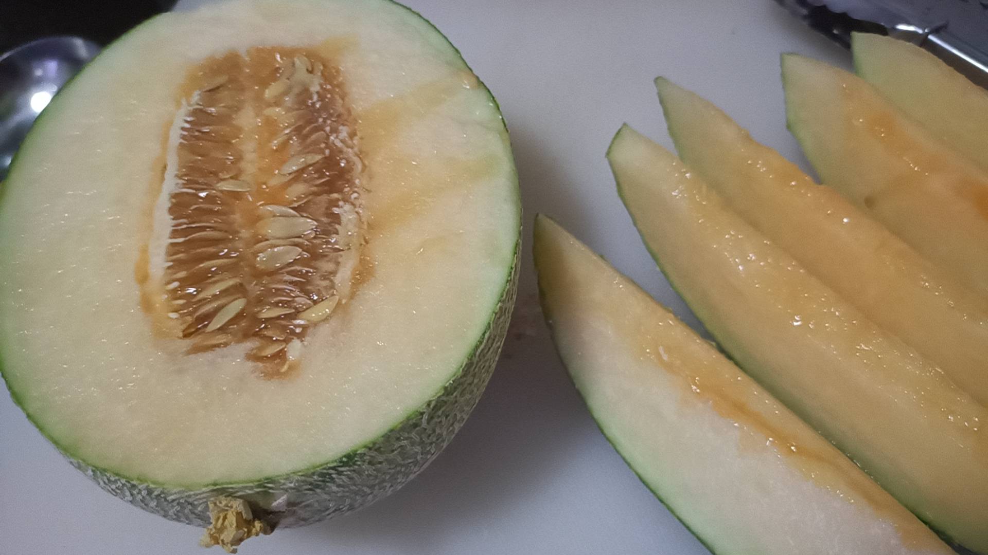 展示新鲜哈密瓜切开后的果肉与营养成分表 哈密瓜切开展示果肉与营养成分