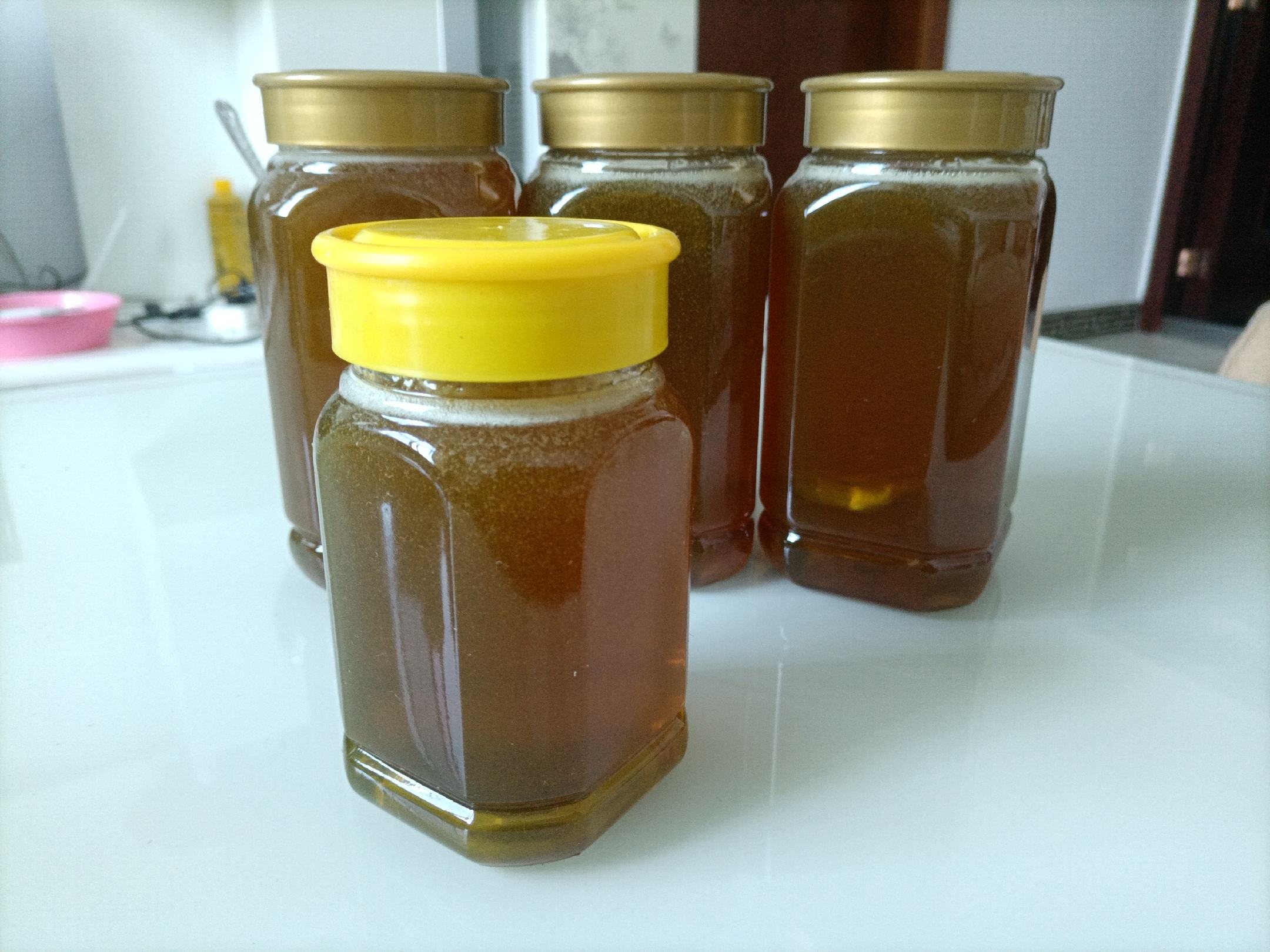 不同种类蜂蜜在白色瓷碗中的对比展示