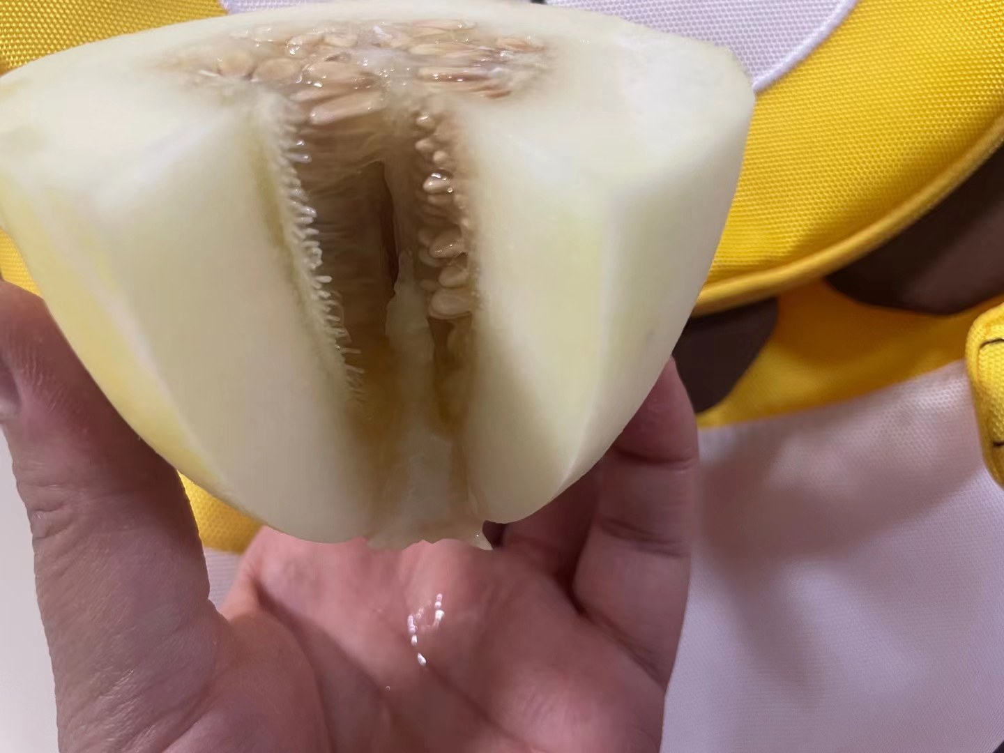 一张高清图片展示新鲜甜瓜切开后的果肉细节,橙黄色果肉清晰可见,背景为自然光线下的厨房环境 甜瓜切开展示果肉与颜色