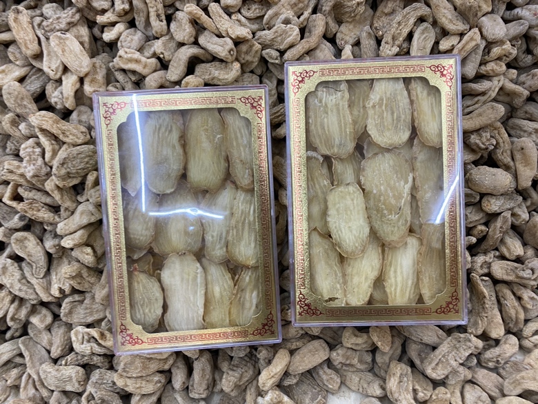 专业农产品摄影:左侧为云南昭通产乌天麻横切片,表面具明显‘鹦哥嘴’顶端与环状横纹,断面角质样半透明;右侧为新疆若羌灰枣整果,果皮深红带霜,褶皱细密均匀,旁置不锈钢电子秤显示单果重8.2g;背景为木质砧板与铜制药碾,突出道地药材属性 天麻与红枣原料对比图