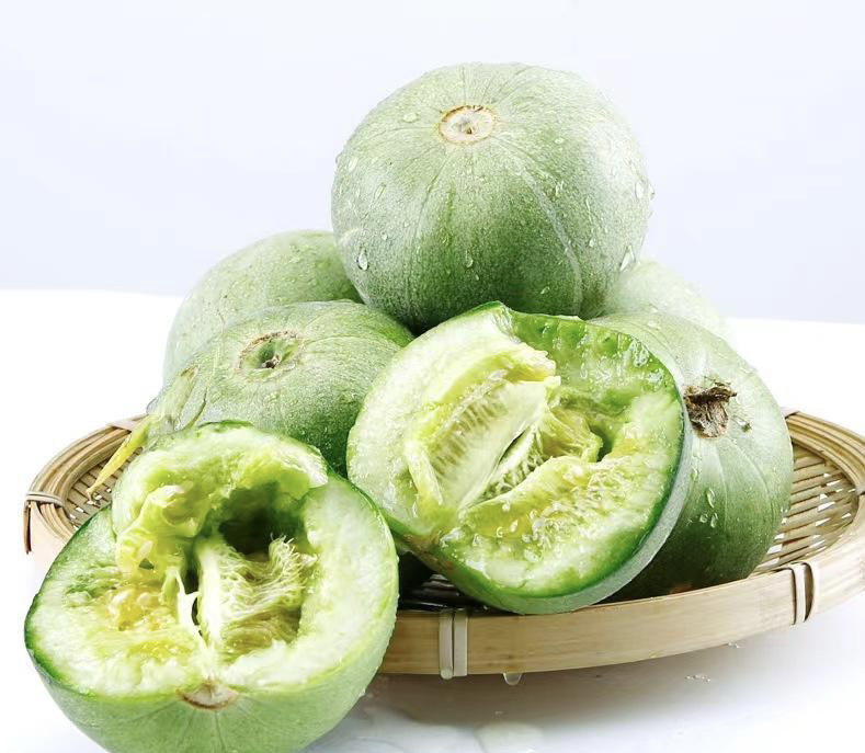 绿宝香瓜科学食用示范:保留可食果皮、搭配紫甘蓝提升VC吸收、避免高温破坏营养,场景化呈现家庭可操作的营养最大化方案 家庭厨房场景:砧板上摆放洗净带皮切片的绿宝香瓜(青绿皮+翠绿肉)、紫甘蓝细丝、柠檬角,旁边小碗盛放少量蜂蜜芥末酱,整体构图体现“连皮食用+抗氧化协同搭配”的健康吃法