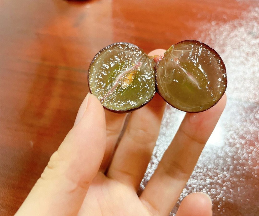 葡萄与葡萄柚对比图,左侧为一串紫红色葡萄,右侧为一个切开的粉红葡萄柚,展示其内部结构 葡萄与葡萄柚对比图