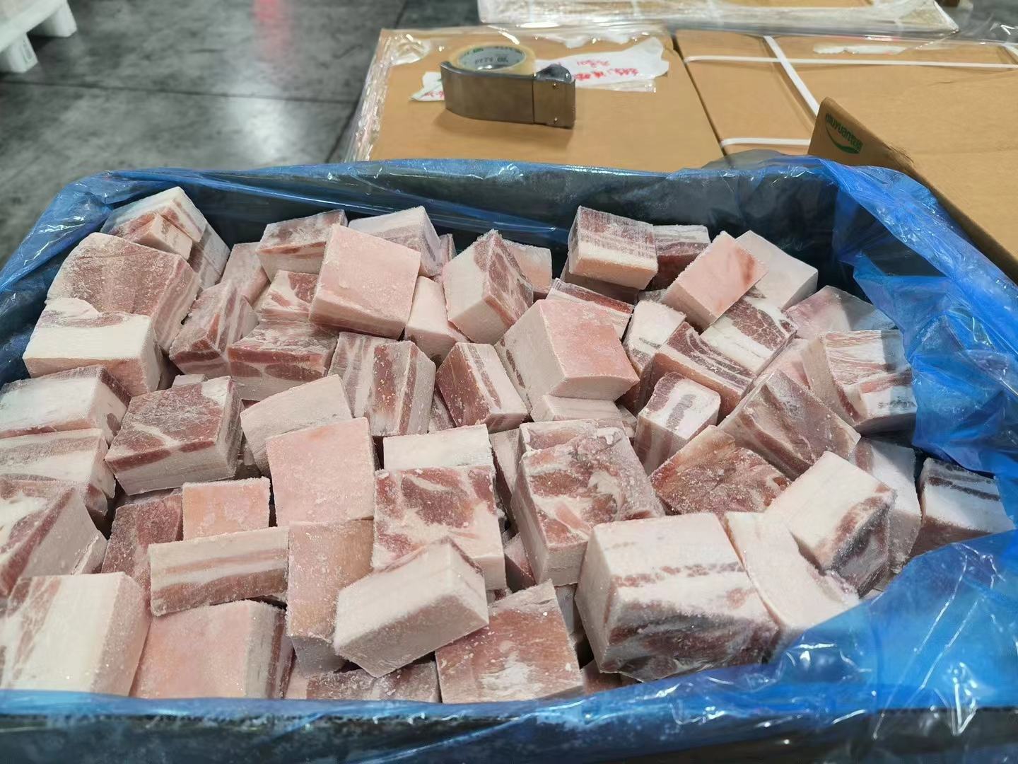 家庭主妇在厨房中将分装好的猪肉放入冰箱冷冻格的场景