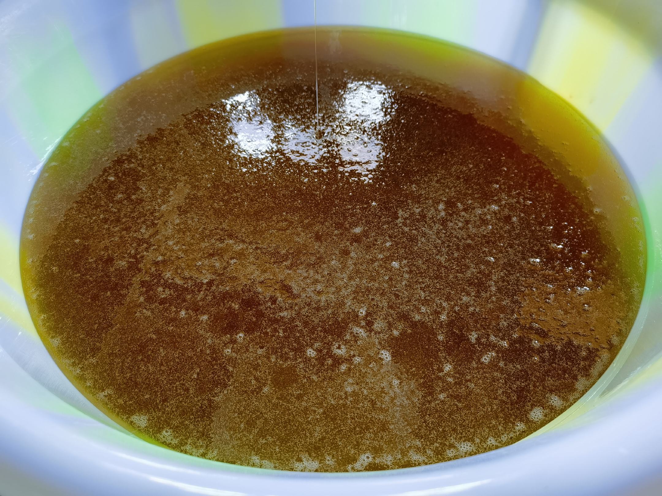 用勺子搅动蜂蜜时产生的大量气泡,显示其粘稠性和含气状态 蜂蜜搅拌气泡图