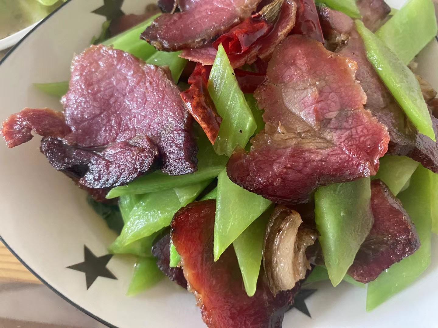 展示正在锅中翻炒的猪肉与蚕豆混合状态 蚕豆与猪肉搭配图