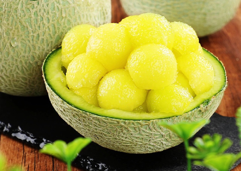 一张切开的网纹瓜图片,展示其金黄色果肉与黑色种子,果肉饱满且水分充足 网纹瓜切开图