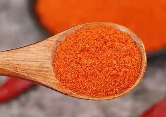 红椒粉装在透明玻璃罐中,标签清晰可见,旁边摆放着木质勺子 红椒粉包装示意图