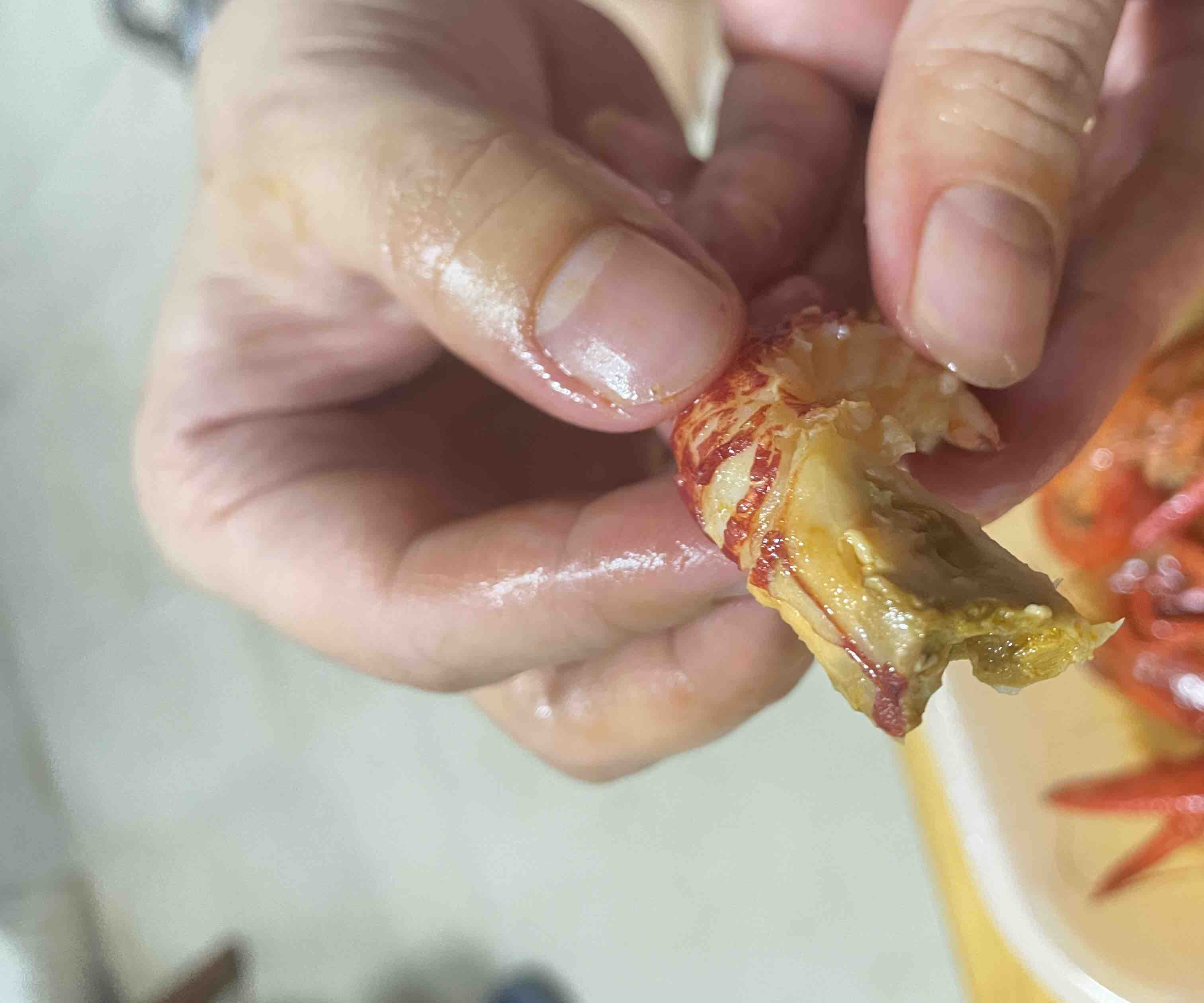 家庭厨房中正在剥小龙虾的人手操作图