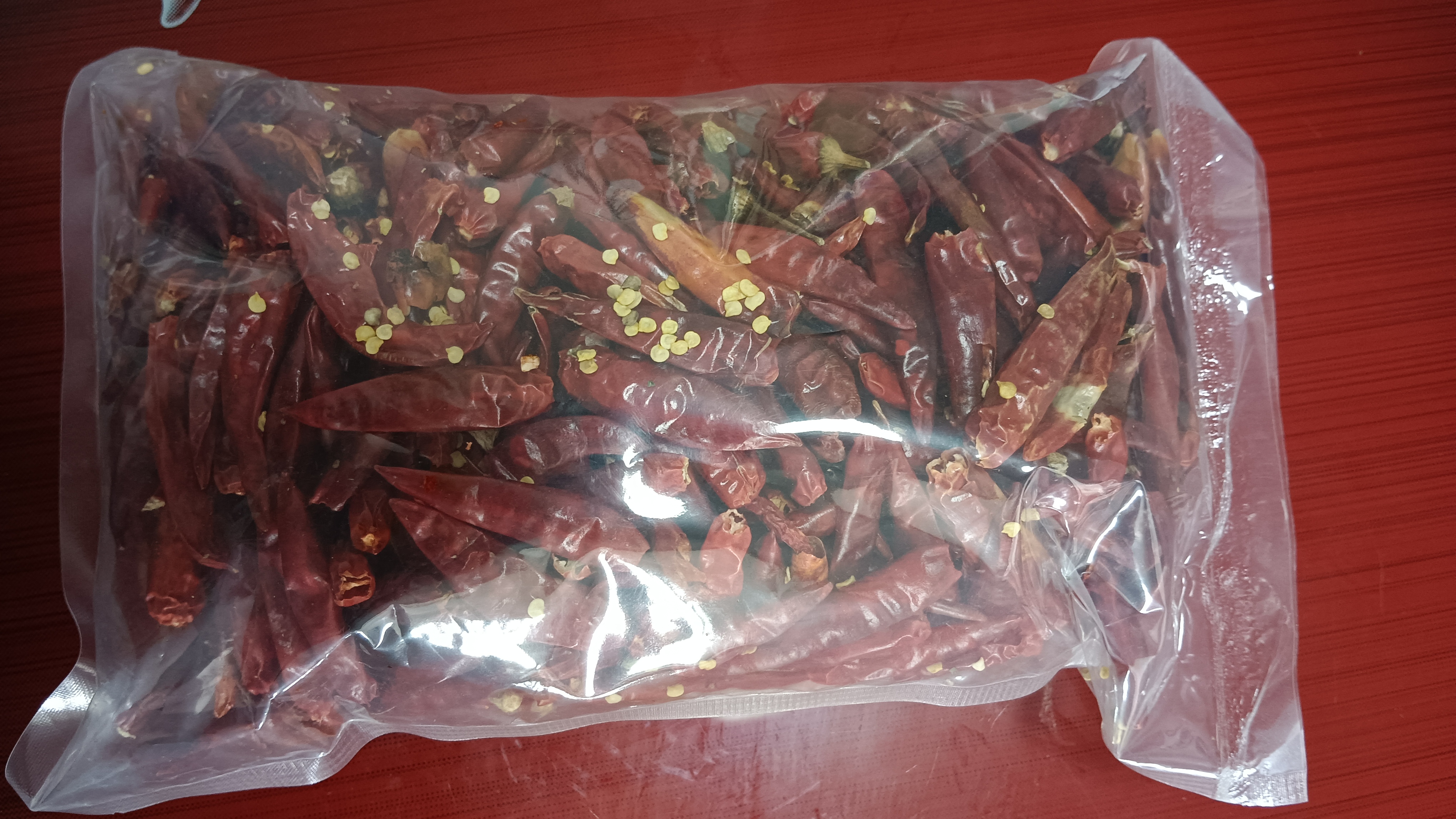 小红椒干制后呈深红色,整齐排列在包装袋中,适合制作辣椒粉或调味料 小红椒干制成品展示