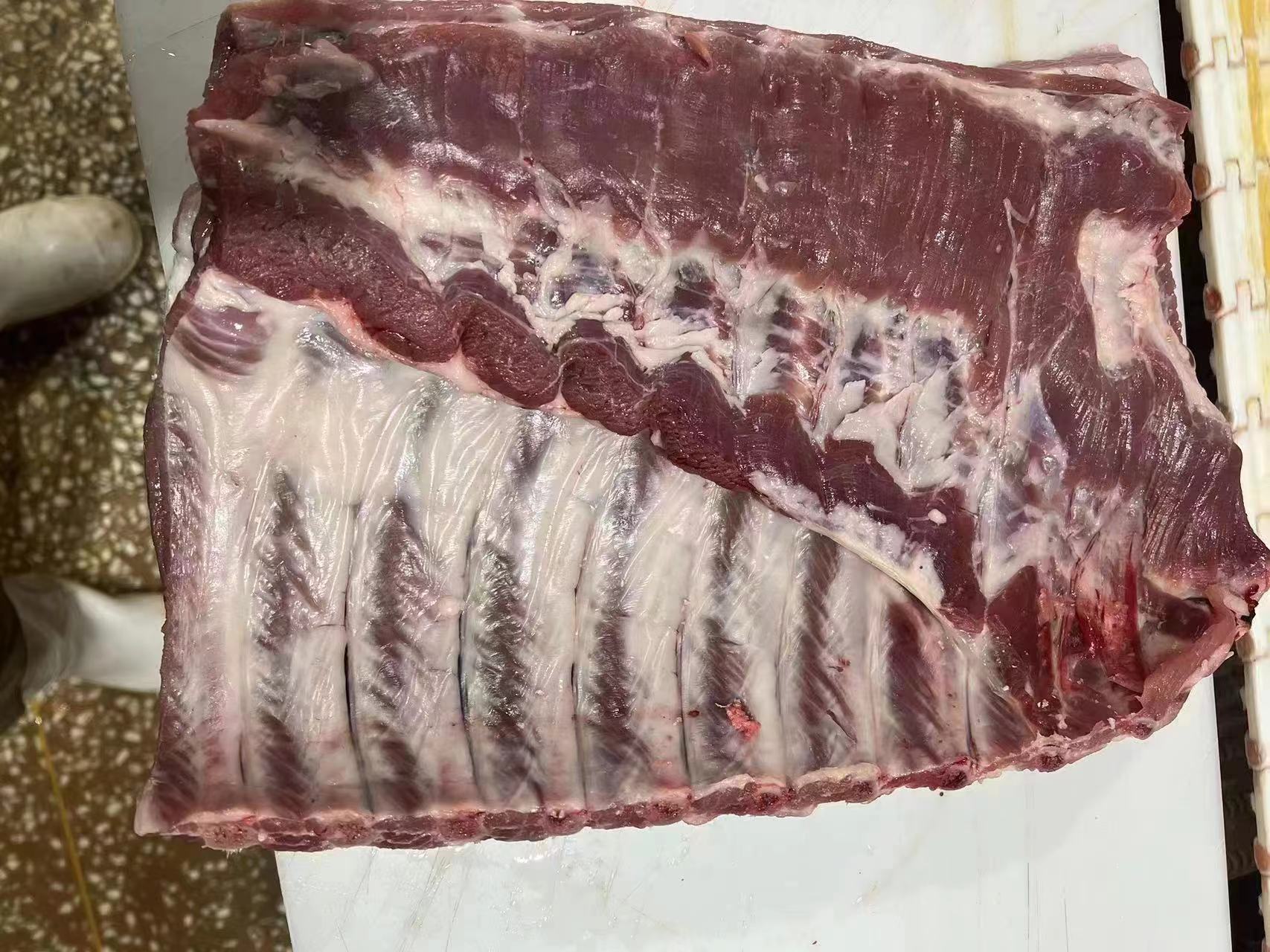 山药土豆排骨生料备料图：左侧不锈钢盆盛焯水后排骨，中间玻璃碗装淡盐醋水浸泡的山药块，右侧竹筐铺厨房纸吸水的土豆块，背景为生姜片、葱结、枸杞、白胡椒罐