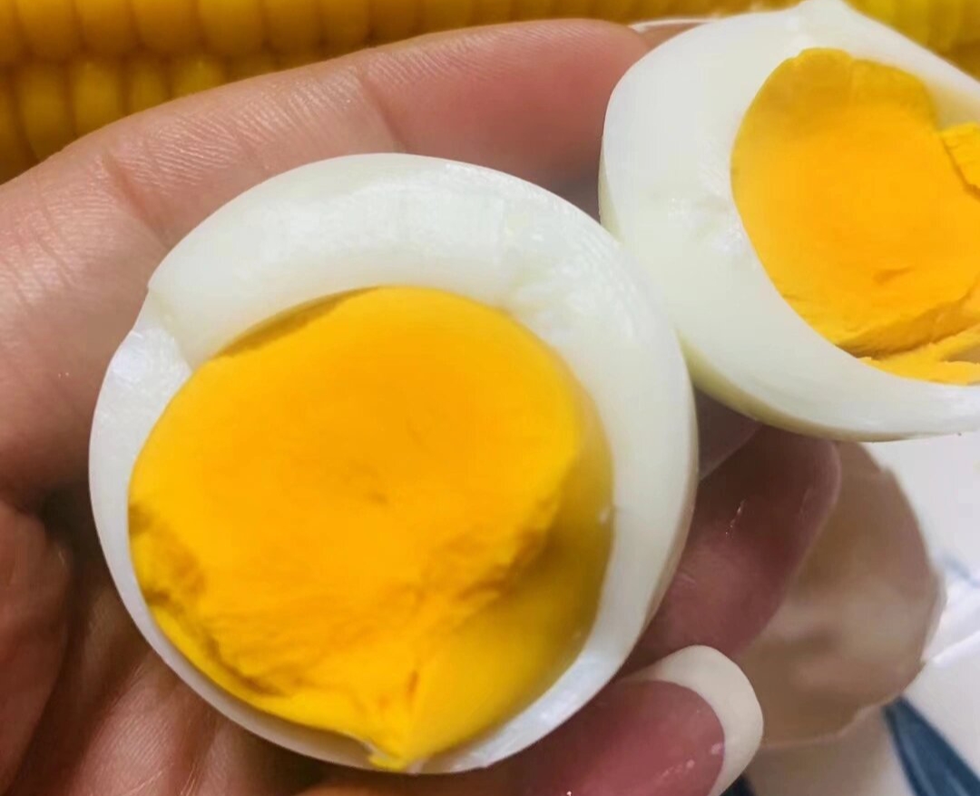 锅中正在小火炖煮的酒糟鸡蛋,蛋壳已剥去,汤汁微微冒泡 酒糟煮鸡蛋制作过程图