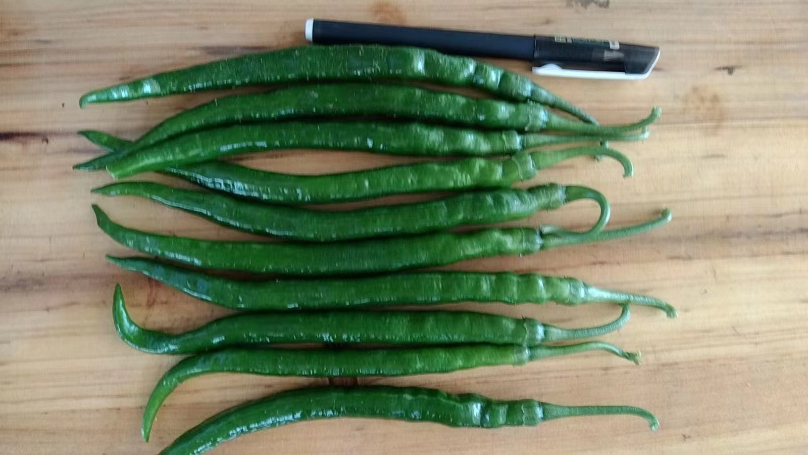 新鲜的螺丝椒与松花蛋摆放在案板上,旁边有蒜末、姜末和小米辣 螺丝椒与松花蛋的食材摆放图