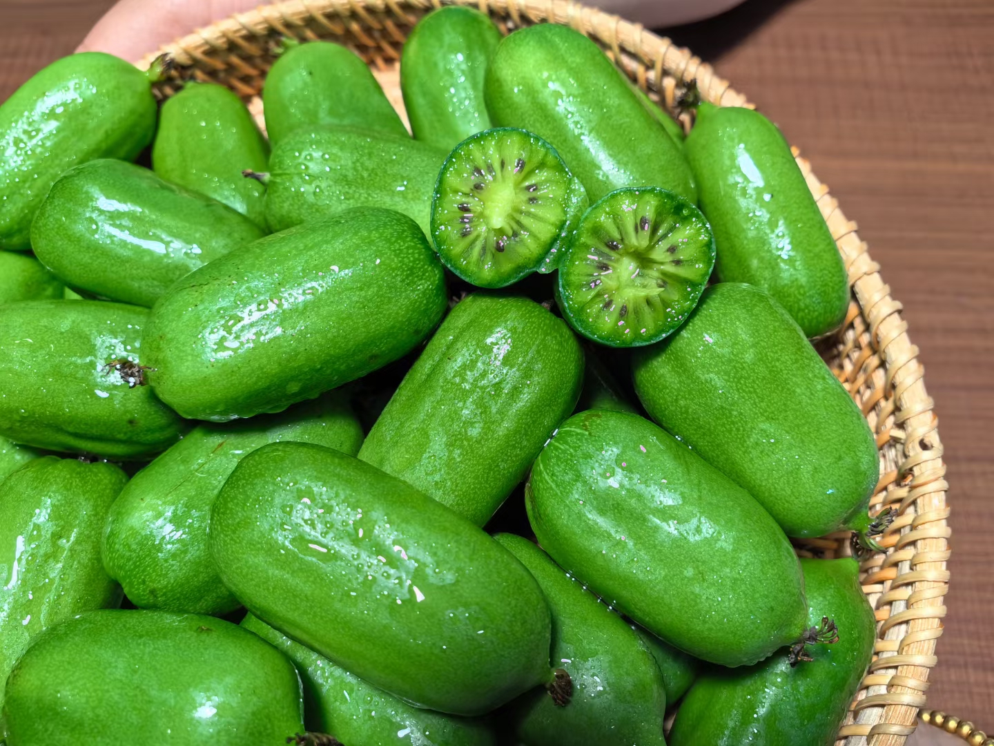 软枣猕猴桃果实在阳光下特写,展示其光滑果皮和绿色果肉 软枣猕猴桃果实在阳光下特写