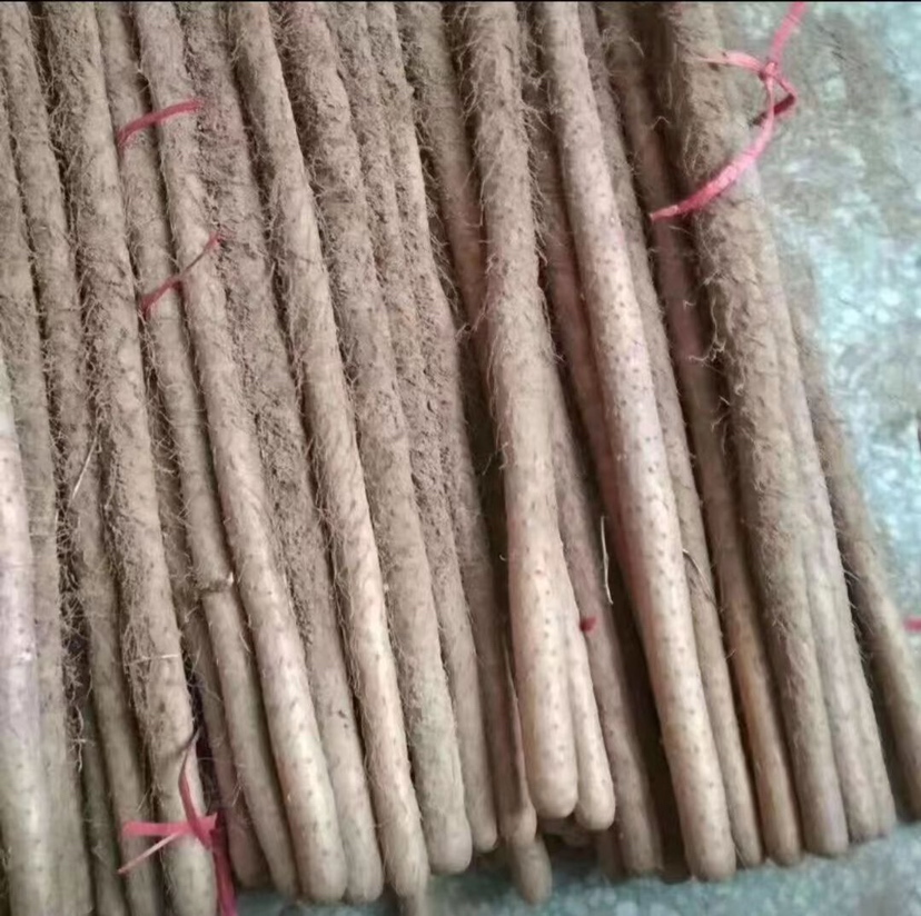 一根完整的双棒山药平放在木质砧板上,表面带有泥土痕迹,呈浅褐色,两端略微弯曲,两根山药并列连接,中间有自然融合的痕迹,背景为柔和自然光下的厨房环境 双棒山药整体外观特写