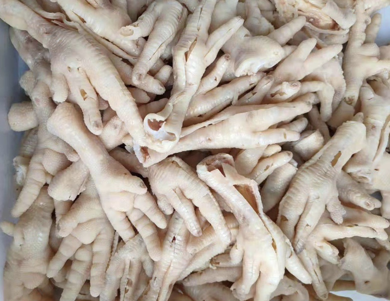 俯拍视角:砂锅内琥珀色卤汤中,雪白鸡爪整齐排列,汤面漂浮着细密金黄色柠檬彩皮丝,两瓣挤汁后的柠檬半果沉于锅底,蒸汽氤氲,展现‘分段入料’的精准工艺 卤制过程中的柠檬皮与鸡爪同锅特写