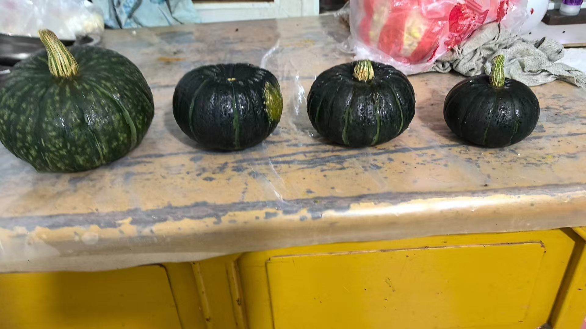 一位老年人与孩子坐在餐桌旁,共同享用一碗金黄色的贝贝南瓜泥,桌上还有一碗清汤和青菜,光线柔和,氛围温馨,体现贝贝南瓜作为家庭营养食材的普适性和安全性,特别强调其在老幼群体中的适用价值 贝贝南瓜与儿童老人共餐场景