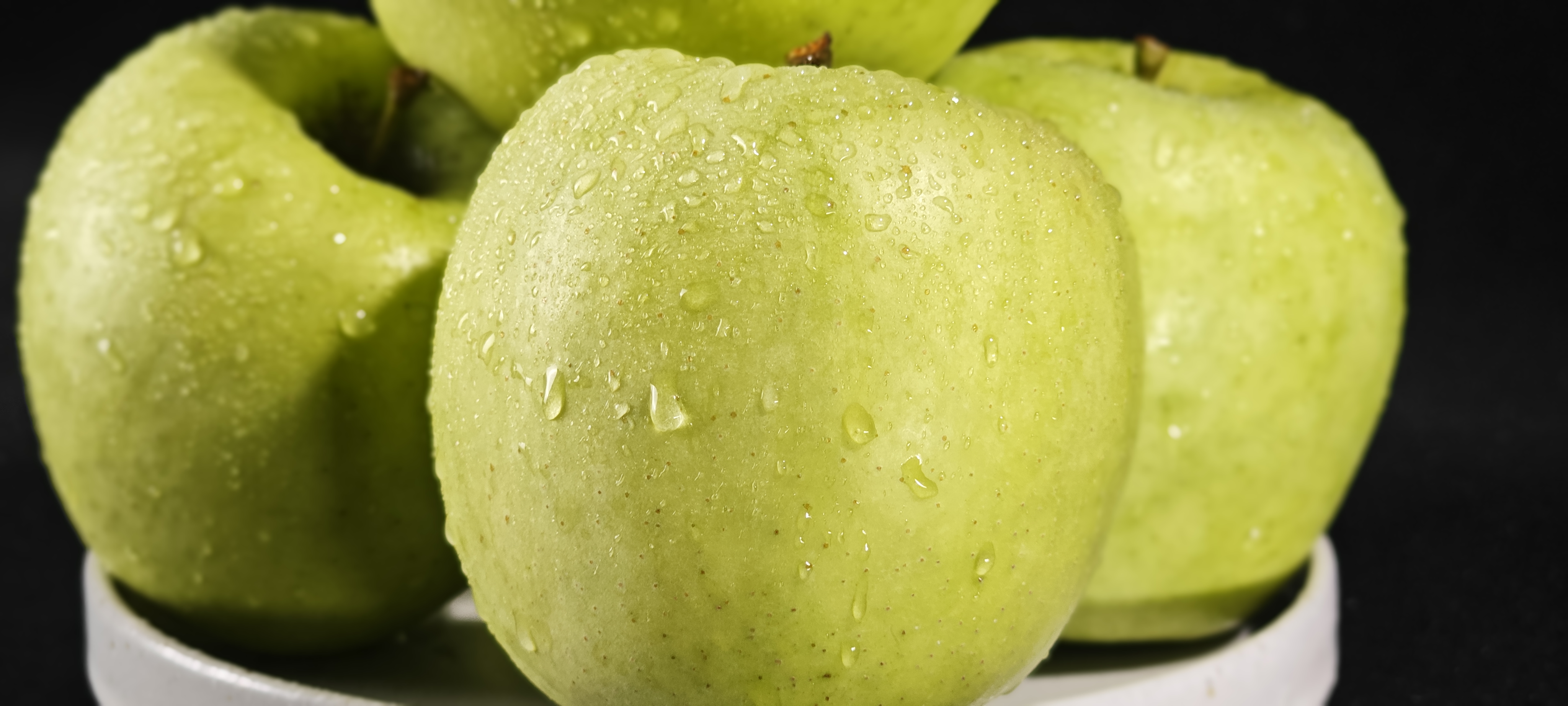 正在用水冲洗嘎啦苹果的过程,水珠在果皮上闪闪发光 嘎啦苹果清洗过程