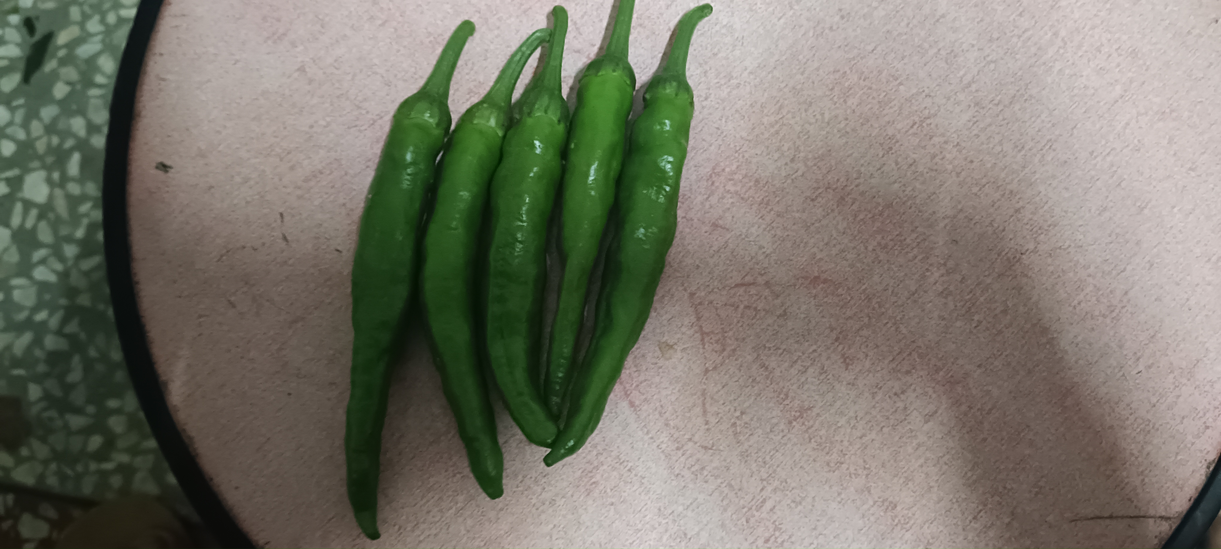 一碗色彩鲜艳的凉拌鲜辣椒丝摆放在木质餐桌上,旁边配有筷子和柠檬装饰 凉拌鲜辣椒成品图