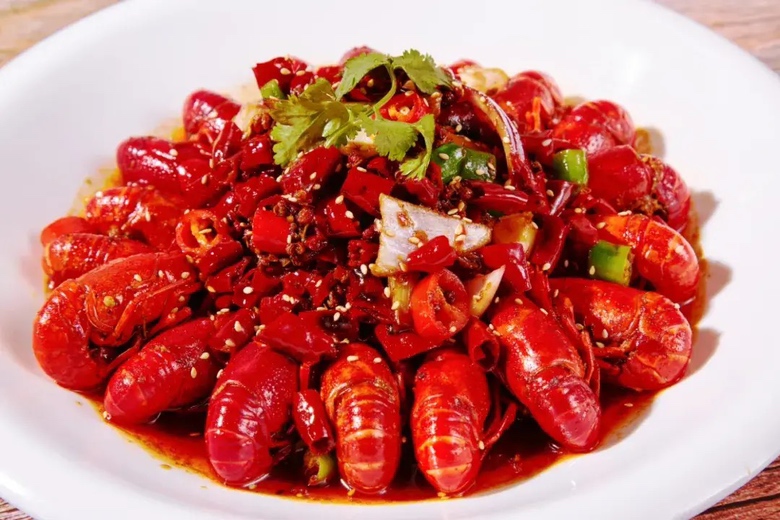 一盘热气腾腾、香气扑鼻的麻辣小龙虾,色泽鲜亮,汤汁浓郁 小龙虾美食图