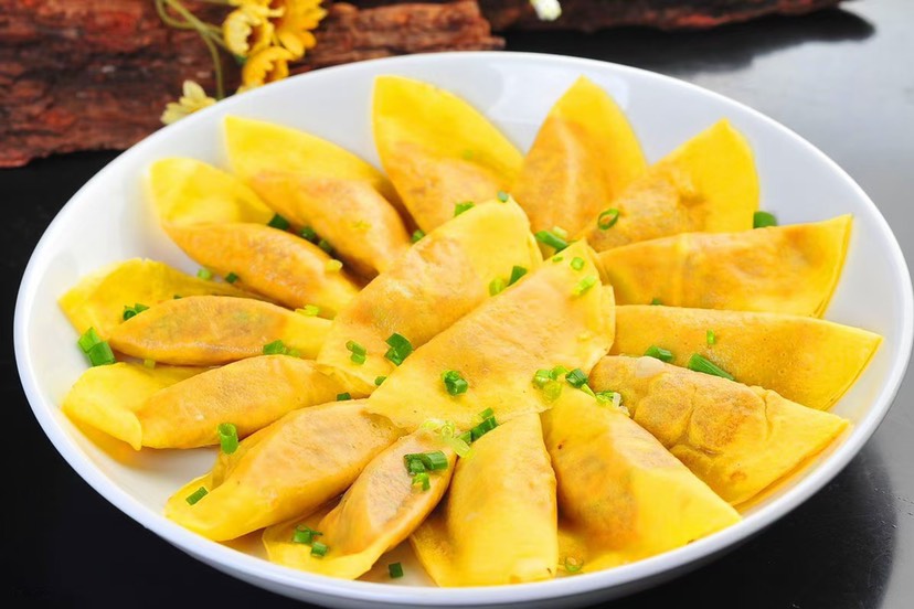 一盘金黄色的洋葱炒鸡蛋摆放在餐桌上,旁边配有白米饭和小葱点缀 成品图:洋葱炒鸡蛋