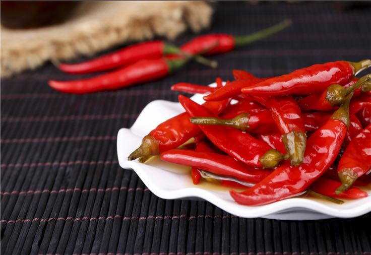 厨师正在锅中翻炒加入泡椒茸的菜肴