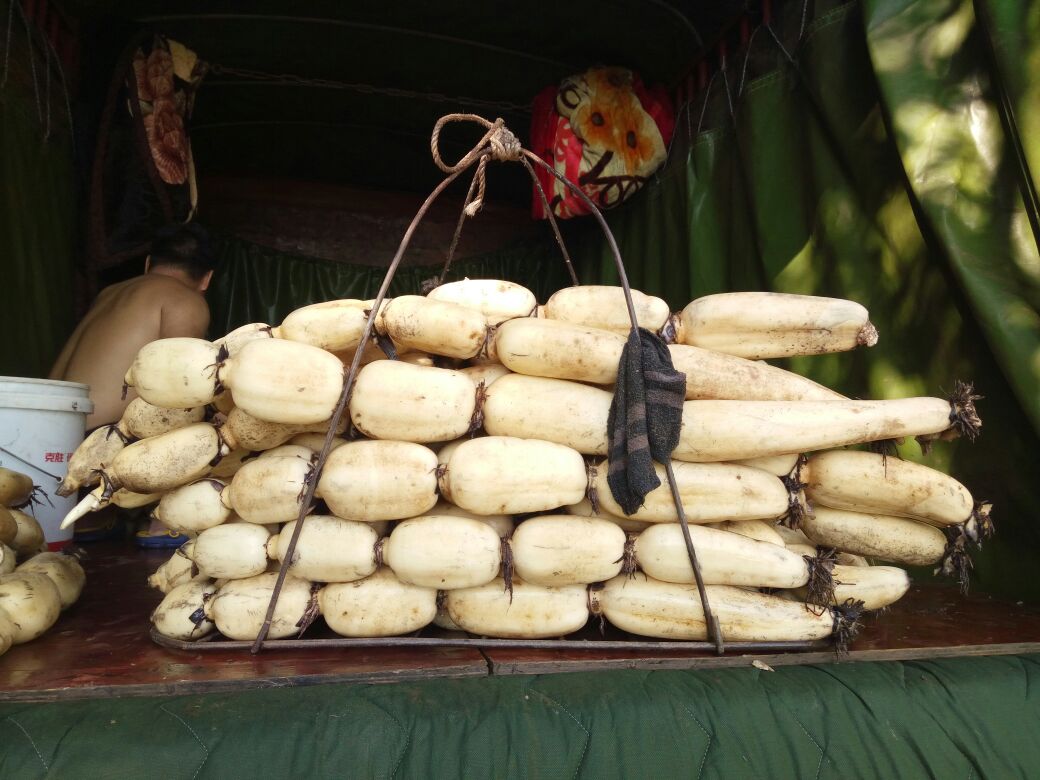 消费者在菜市场挑选莲藕的场景