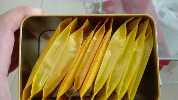 透明密封袋装的干燥野菊花,花朵完整呈金黄色,背景为带有‘有机认证’标签和产地信息(湖北大别山)的纸卡,展示高品质农产品包装细节 市售优质野菊花包装样品