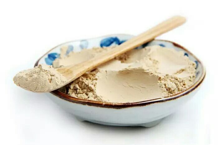 一位年轻男性在早餐桌上将一勺黑玛卡粉末倒入搅拌机,搅拌机中已有香蕉、牛奶和蓝莓;旁边摆放着开放式包装的黑玛卡罐子,标签可见‘Black Maca Powder’和‘Andes Mountains Origin’字样,背景为清晨阳光照进厨房的温馨场景 黑玛卡日常食用场景示意图