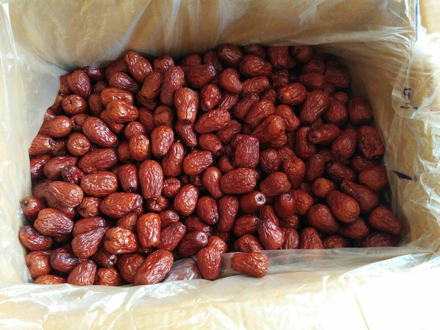 木质托盘上摆放着不同规格的新疆骏枣产品,包括散装干枣、真空小包装、礼盒装、枣夹核桃组合装,背景为现代仓储货架,标签清晰标注产地为新疆阿克苏 骏枣产品展示图