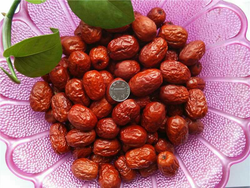 一盘金黄色的灰枣圈整齐摆放在木质托盘中,背景为阳光照射下的若羌枣园,枣圈表面有自然褶皱,呈现出饱满油润的质感,部分带有轻微白霜(天然糖分析出),体现高品质特征 灰枣圈特写