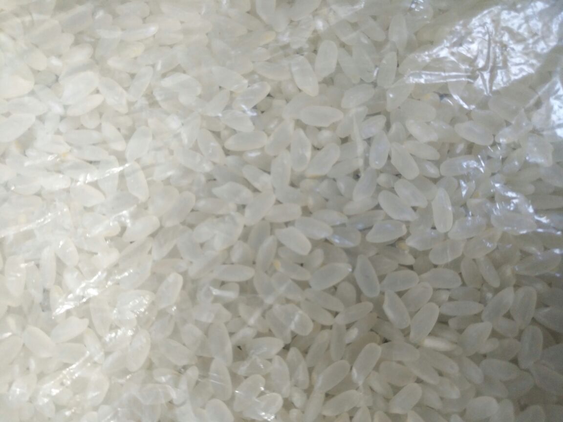 桌面上摆放柴火大院长粒香大米的正品包装袋,正面清晰显示品牌LOGO、产品名称、净重5kg、产地黑龙江五常,背面贴有二维码标签,手指正扫描溯源码,屏幕显示生产批次、检测结果等详细信息 柴火大院大米包装与溯源信息展示