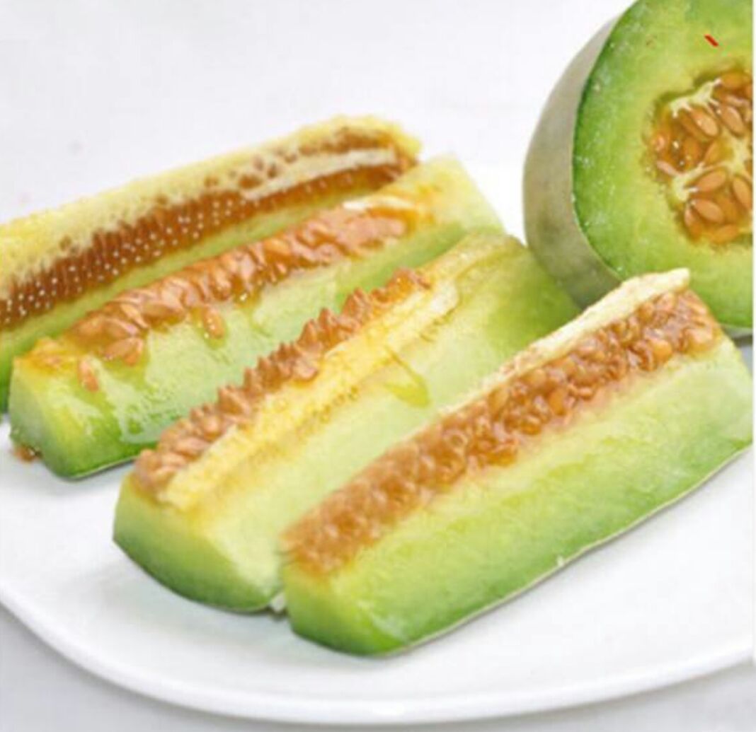 甜瓜预处理特写：去皮去籽后的淡橙色立方块整齐排列在竹筛上，表面干燥无水光，背景为木质料理台