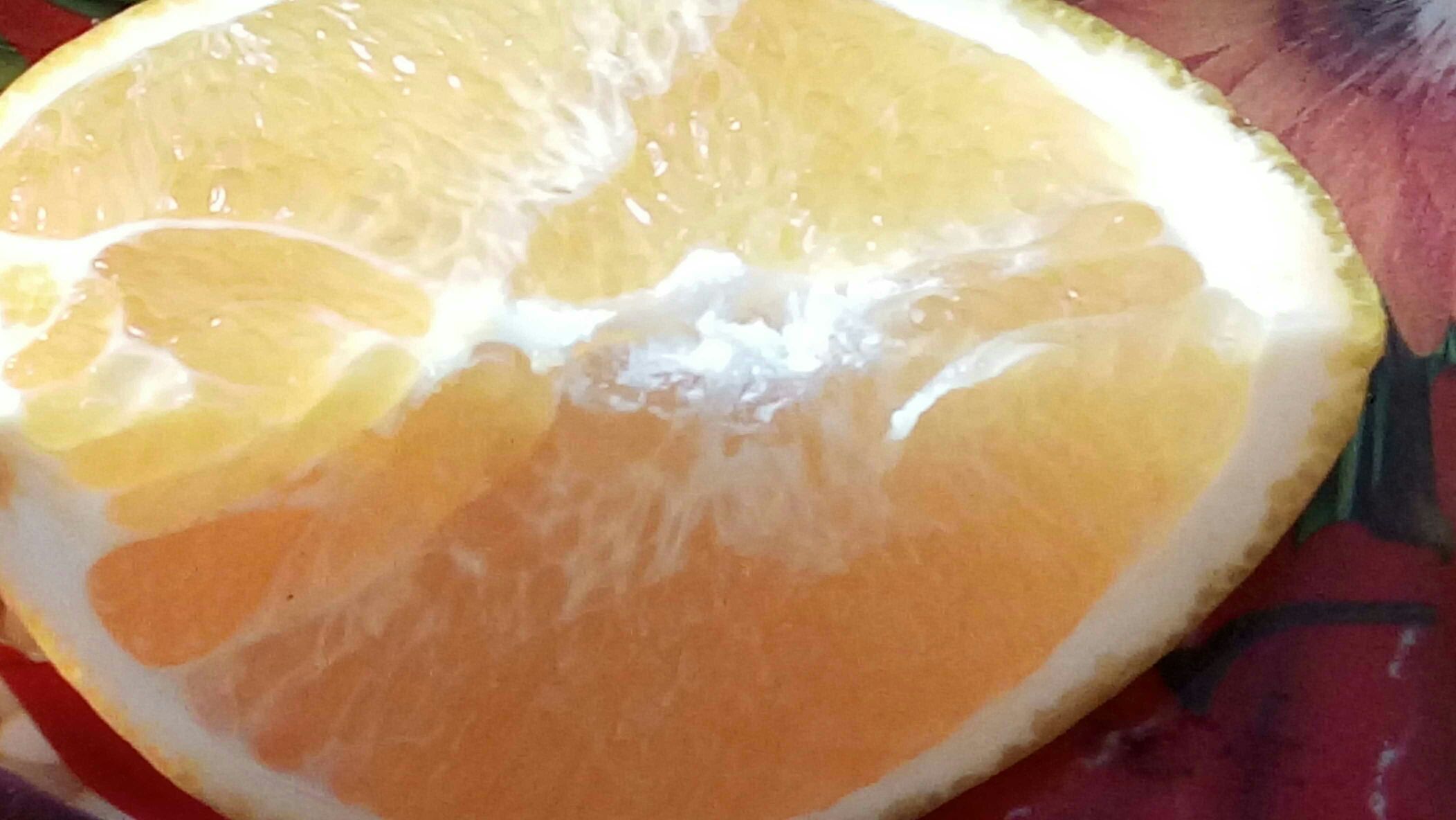展示一颗成熟的大甜橙,果皮橙红、表面光滑,切开后果肉饱满多汁 大甜橙果实特写