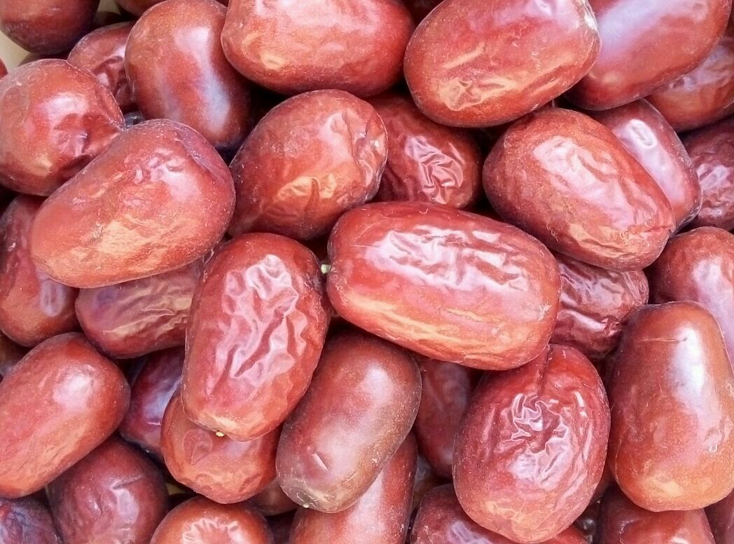 新鲜骏枣的特写镜头,展示其饱满的果实和鲜亮的红色外皮 鲜骏枣特写