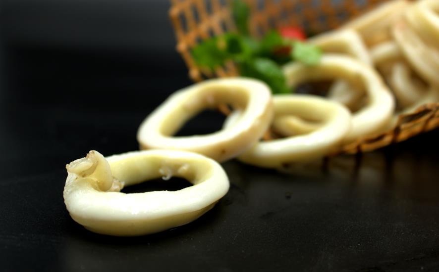 餐桌上摆放着一份清蒸鱿鱼和一杯黑咖啡,营造出轻松的用餐氛围 鱿鱼与咖啡同桌画面