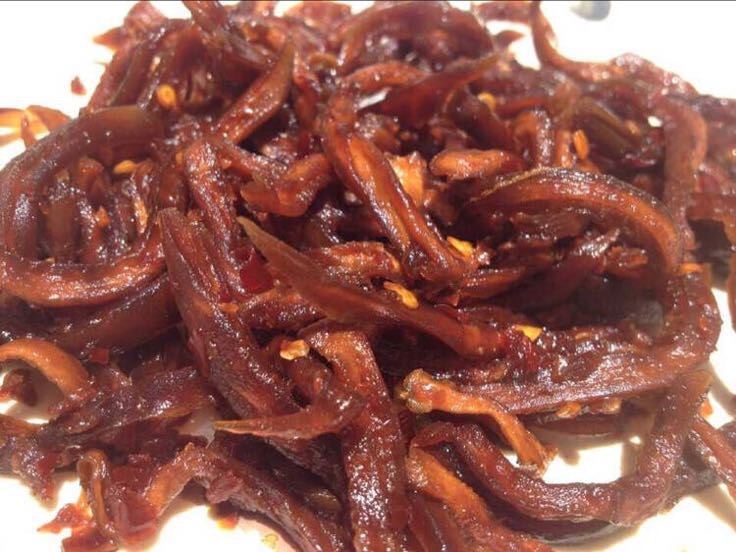 天然无添加木瓜干产品展示图,金黄色半透明果干平铺于竹盘,包装袋清晰标注成分和保质期,突出健康食品属性 透明密封袋装金黄色木瓜干片,散落在竹制托盘上,旁边有干燥剂包和标签纸