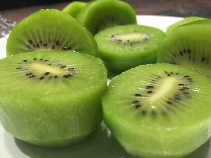 图片说明:左侧为切开的杨桃,呈五角星状;右侧为海沃德猕猴桃,果肉翠绿,果形椭圆 杨桃与海沃德猕猴桃对比图