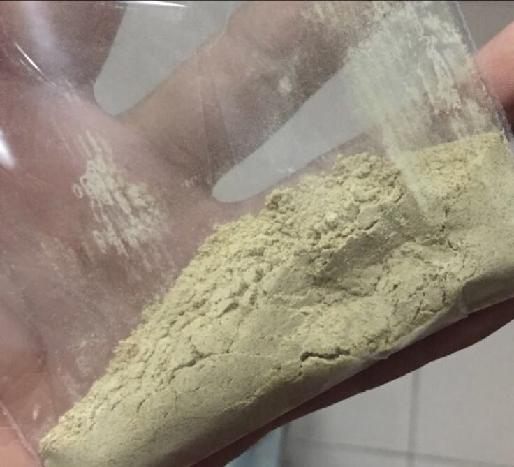 一个白色瓷碗中盛有棕黄色三七粉末,旁边倒入少量透明黄酒液体,一只手正用小木勺搅拌形成粘稠药糊;背景可见人体腰部轮廓图,标注‘肾区’与‘疼痛点’,示意外敷位置 三七粉与黄酒调制外敷过程示意图