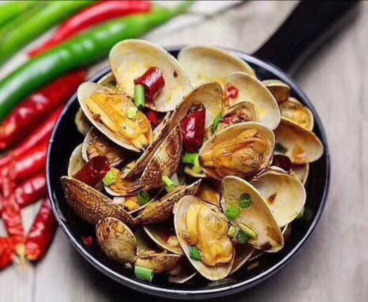 锅中翻炒的螺丝椒与扇贝,香气四溢 翻炒过程中的螺丝椒与扇贝