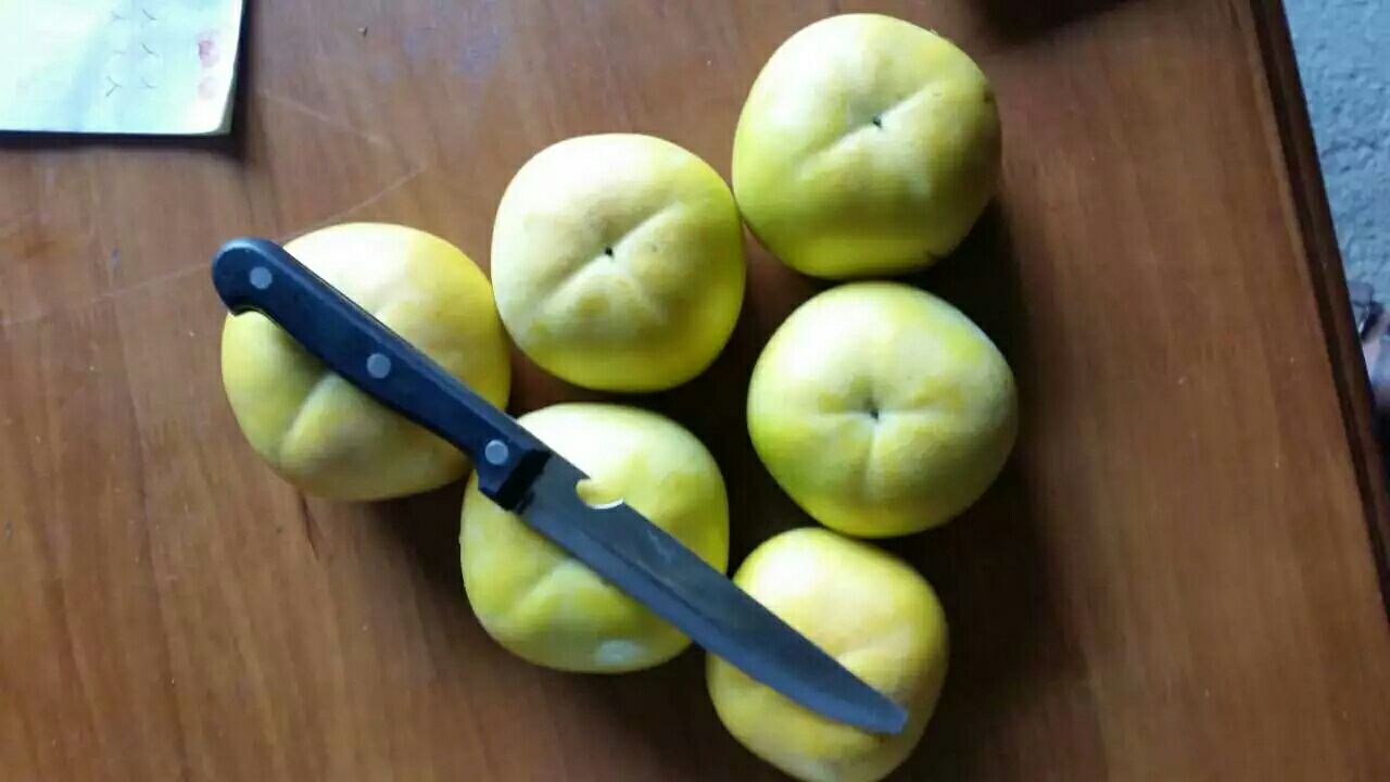一位怀孕女性正在削脆柿,桌上摆放着水果刀和盘子 孕期准妈妈食用脆柿